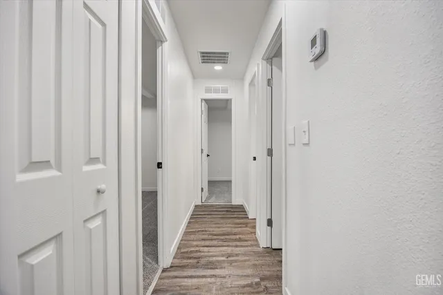 a view of a hallway with wooden floor and staircase