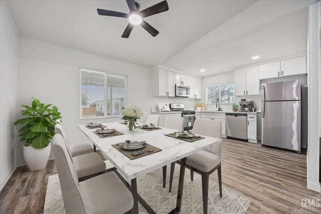 a kitchen with a dining table chairs and refrigerator