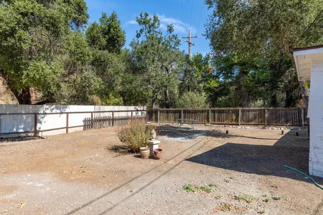a view of a roof deck with couches and wooden fence