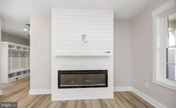 a living room with a fireplace and wooden floor