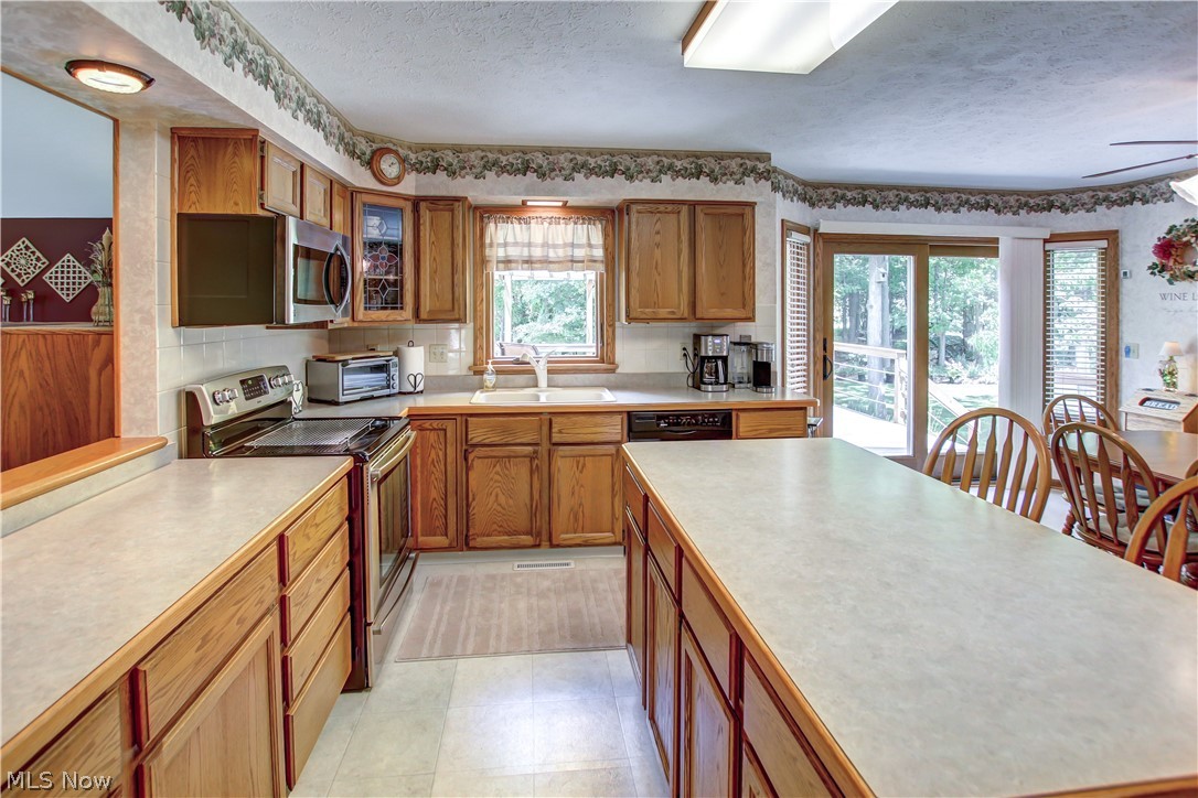 1010 Rustic Trail Cleveland, OH 44134 - Photo 2 of 49 Kitchen featuring ceiling fan, stainless steel appliances, light tile flooring, a textured ceiling, and sink