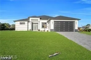 a front view of a house with a garden and yard