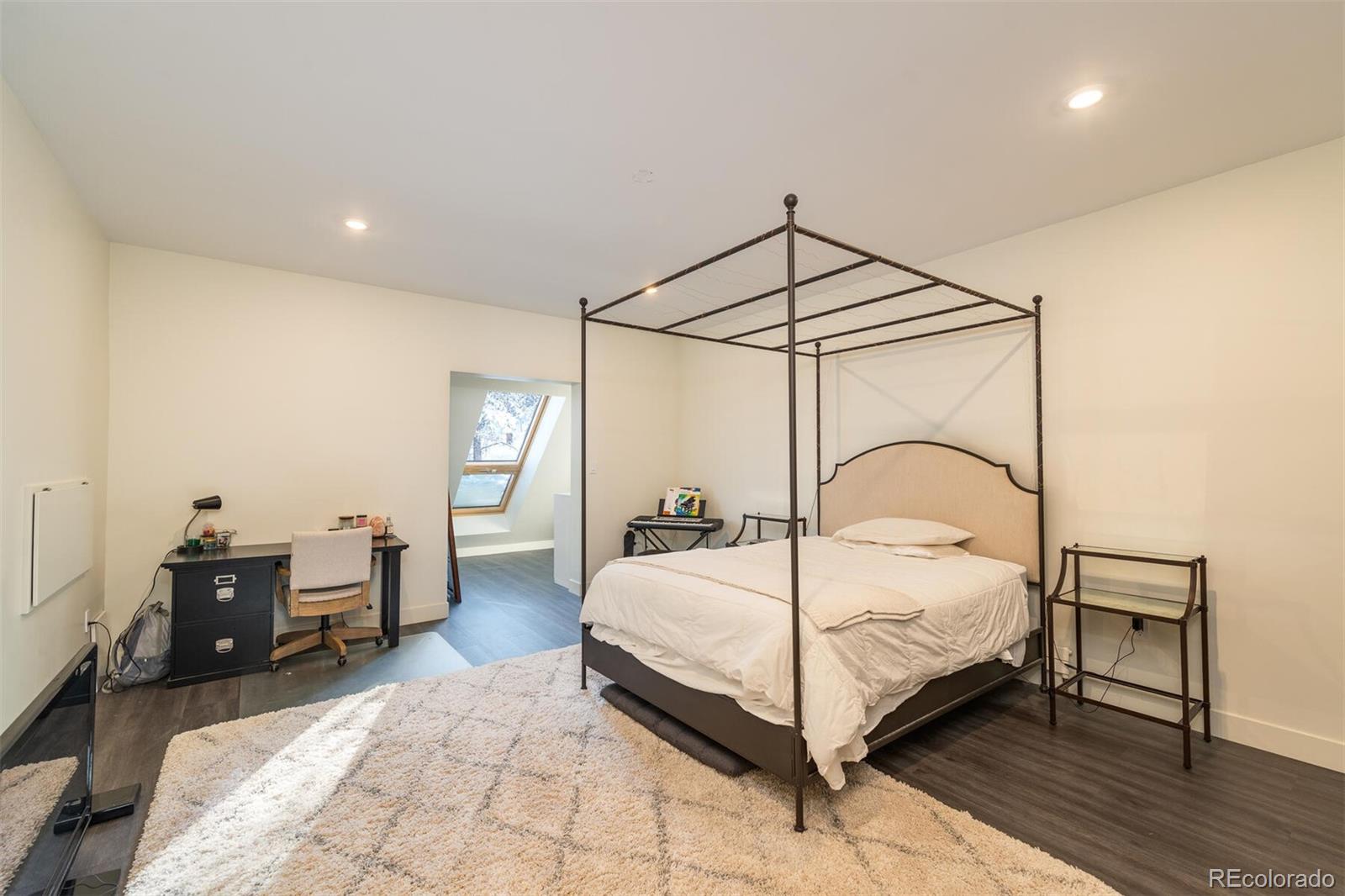 1791 Kerr Gulch Road Evergreen, CO 80439 - Photo 25 of 40 a bedroom with a bed lamp closet and a mirror
