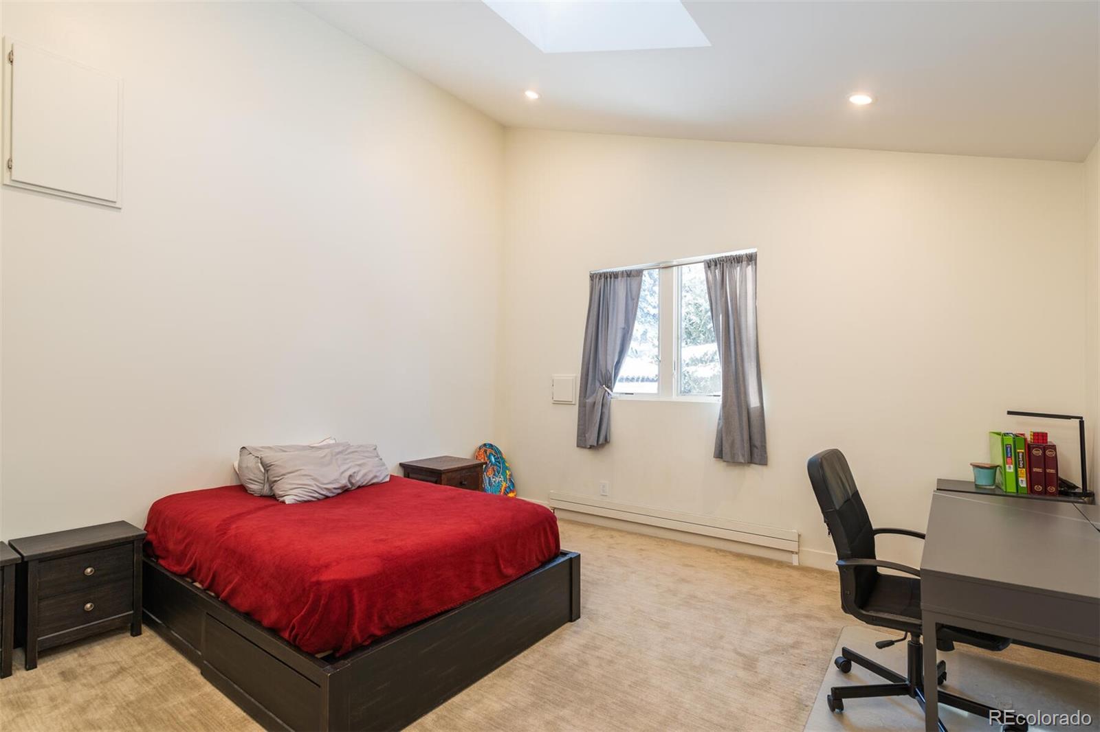 1791 Kerr Gulch Road Evergreen, CO 80439 - Photo 27 of 40 a spacious bedroom with a bed and a desk
