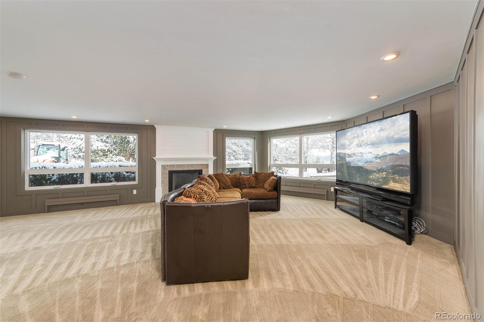 1791 Kerr Gulch Road Evergreen, CO 80439 - Photo 29 of 40 a living room with fireplace furniture and a flat screen tv