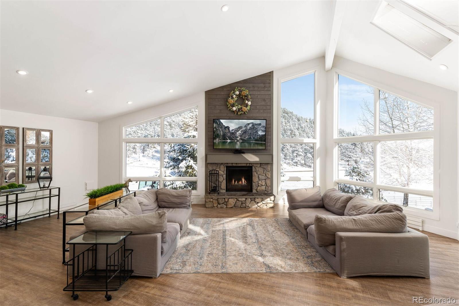 1791 Kerr Gulch Road Evergreen, CO 80439 - Photo 4 of 40 a living room with furniture large window and fireplace