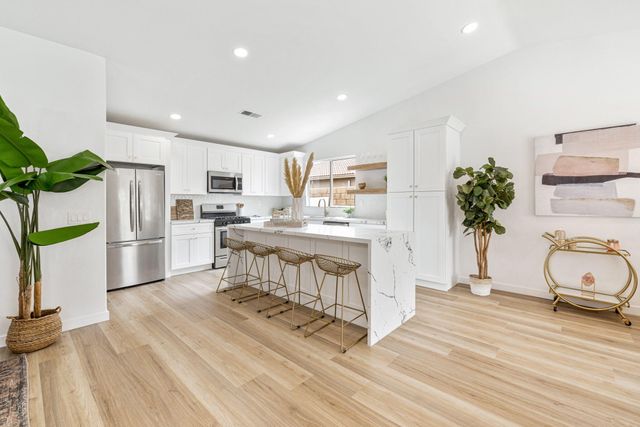 a kitchen with a sink cabinets and wooden floor