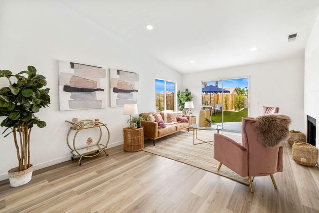 a kitchen with stainless steel appliances a sink a stove a refrigerator cabinets and a dining table