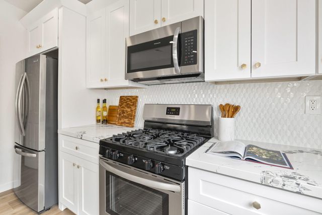 a large white bed sitting in a living room next to a window