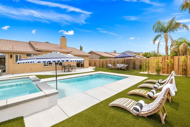 a view of a house with swimming pool and sitting area
