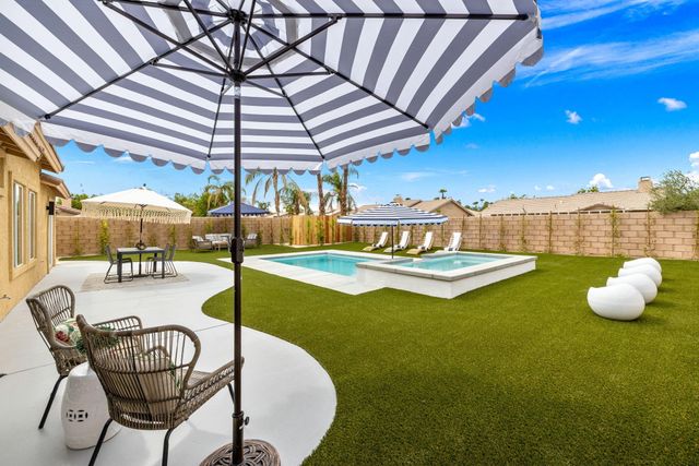 a view of swimming pool with outdoor seating and yard in the back