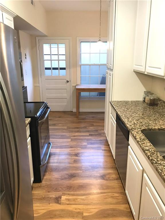 5941 Quail Hollow Road Charlotte, NC 28210 - Photo 5 of 20 a kitchen with granite countertop a refrigerator a sink a stove a washer and dryer