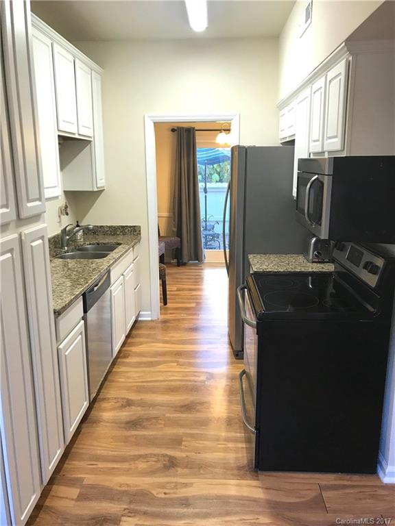 5941 Quail Hollow Road Charlotte, NC 28210 - Photo 6 of 20 a kitchen with stainless steel appliances granite countertop a refrigerator a stove and a wooden floors