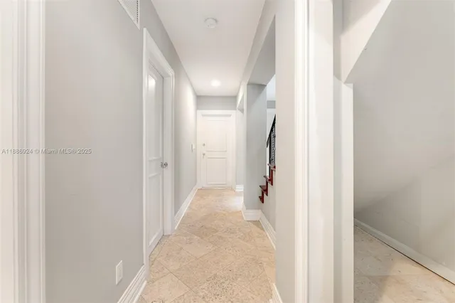 a view of a hallway with white walls and stairs