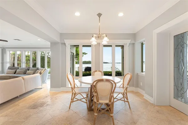 a view of a dining room with furniture large windows and wooden floor