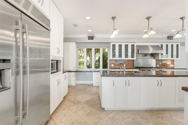 a large kitchen with kitchen island granite countertop a large counter top stainless steel appliances and cabinets