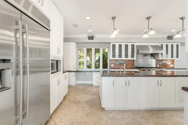 a large kitchen with kitchen island granite countertop a large counter top stainless steel appliances and cabinets