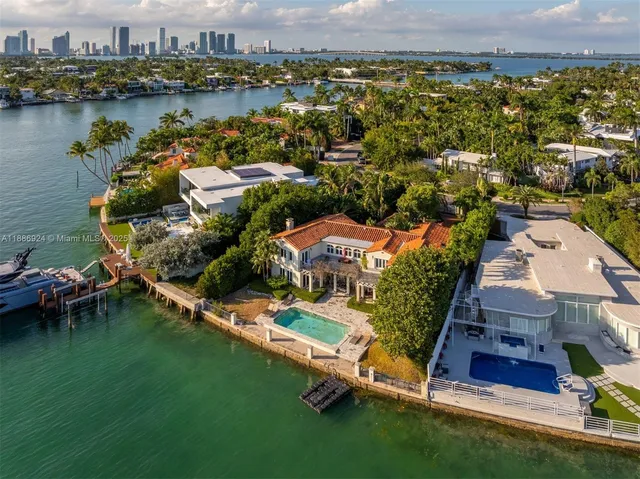 an aerial view of residential houses with outdoor space and lake view