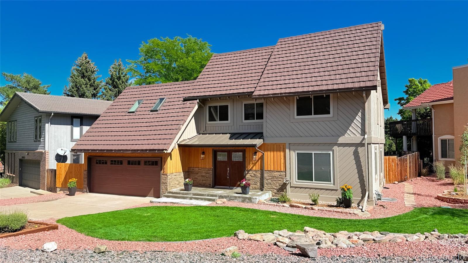 a front view of a house with a yard and potted plants