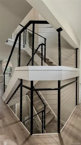 a view of a hallway with wooden floor and a living room