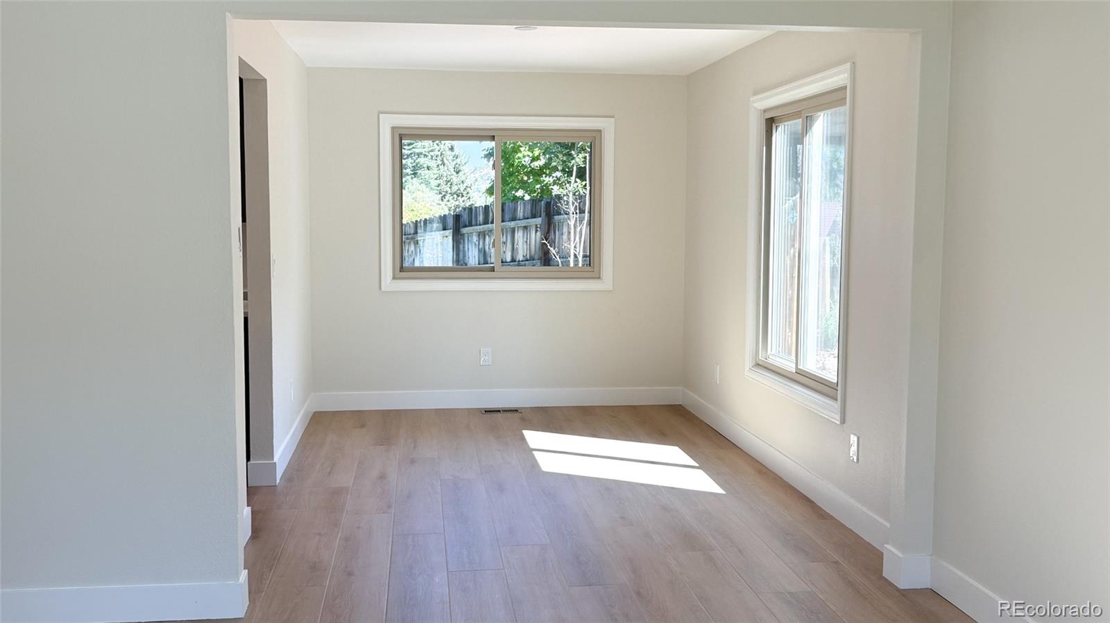 15789 Sandtrap Way Morrison, CO 80465 - Photo 20 of 34 an empty room with wooden floor and windows