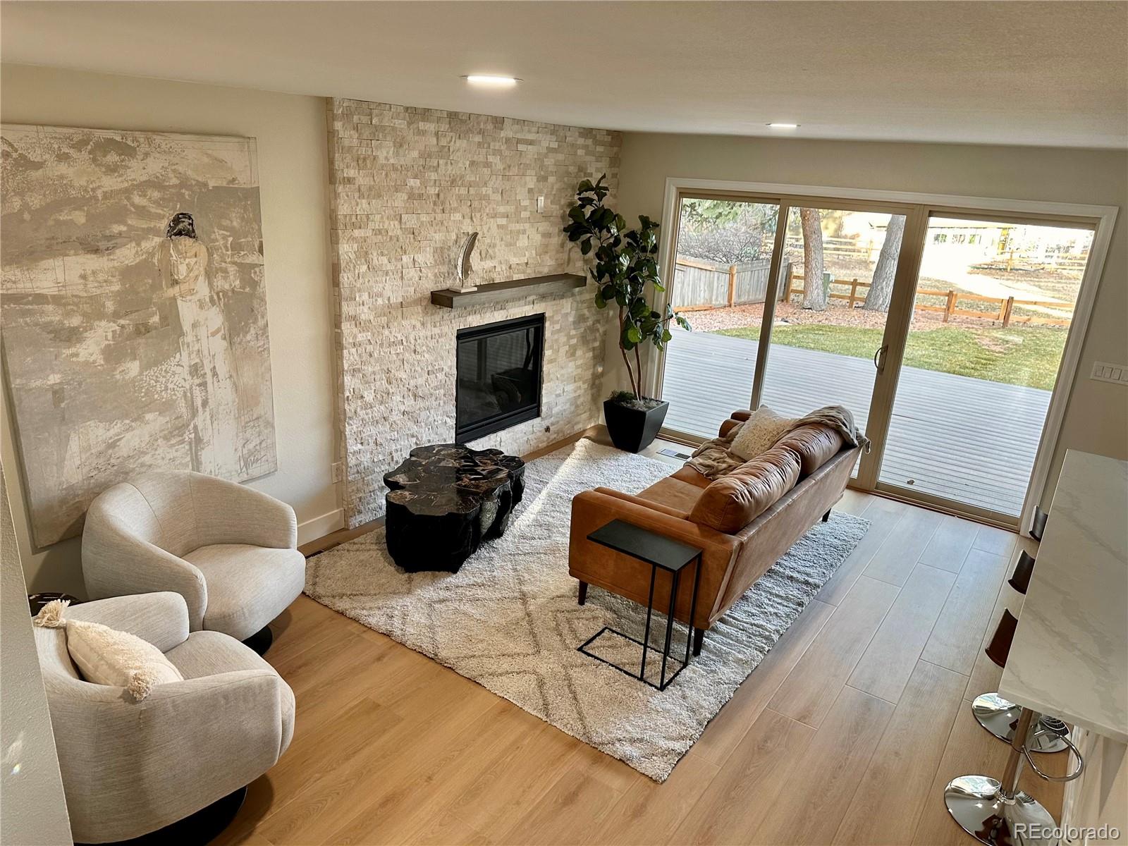 15789 Sandtrap Way Morrison, CO 80465 - Photo 2 of 34 a living room with furniture a flat screen tv and a fireplace