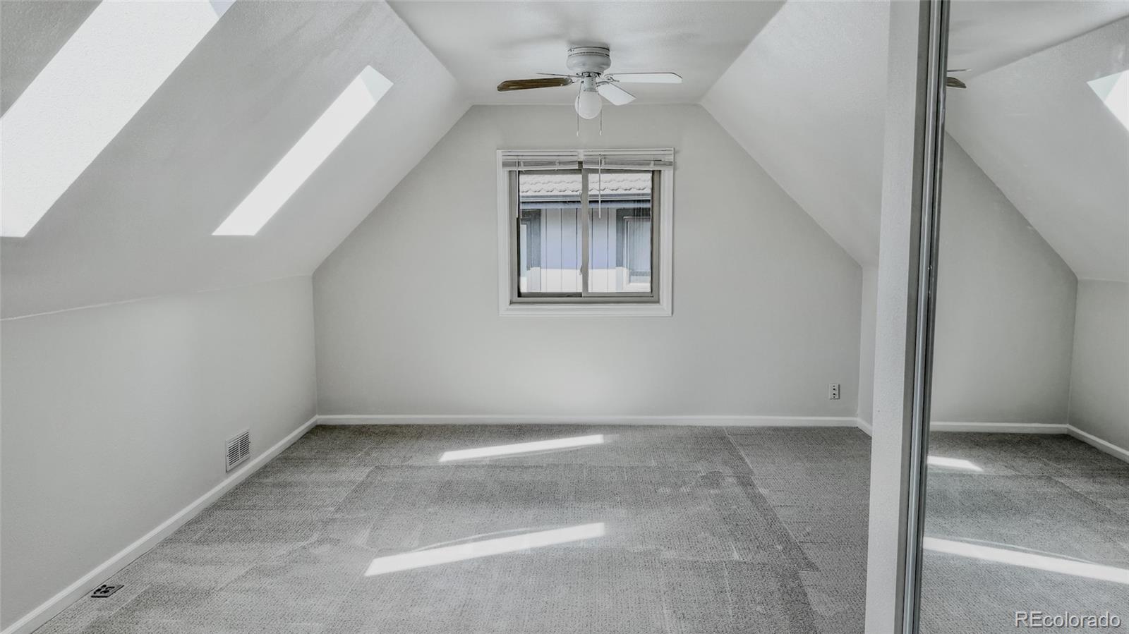 15789 Sandtrap Way Morrison, CO 80465 - Photo 28 of 42 an empty room with a ceiling fan and window