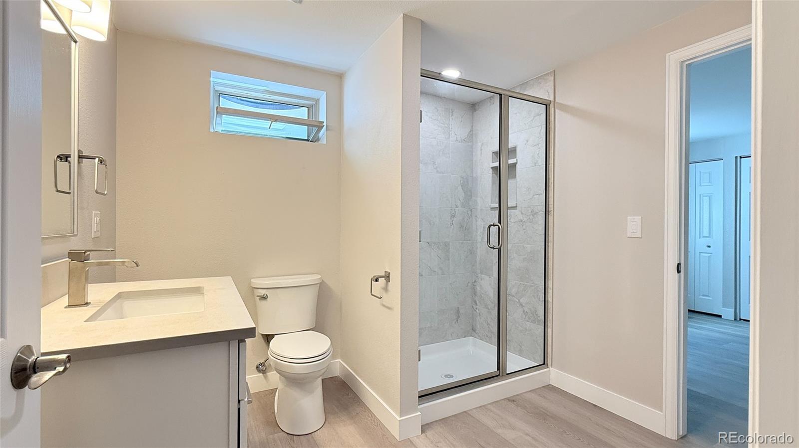 15789 Sandtrap Way Morrison, CO 80465 - Photo 30 of 34 a bathroom with a toilet a sink and shower