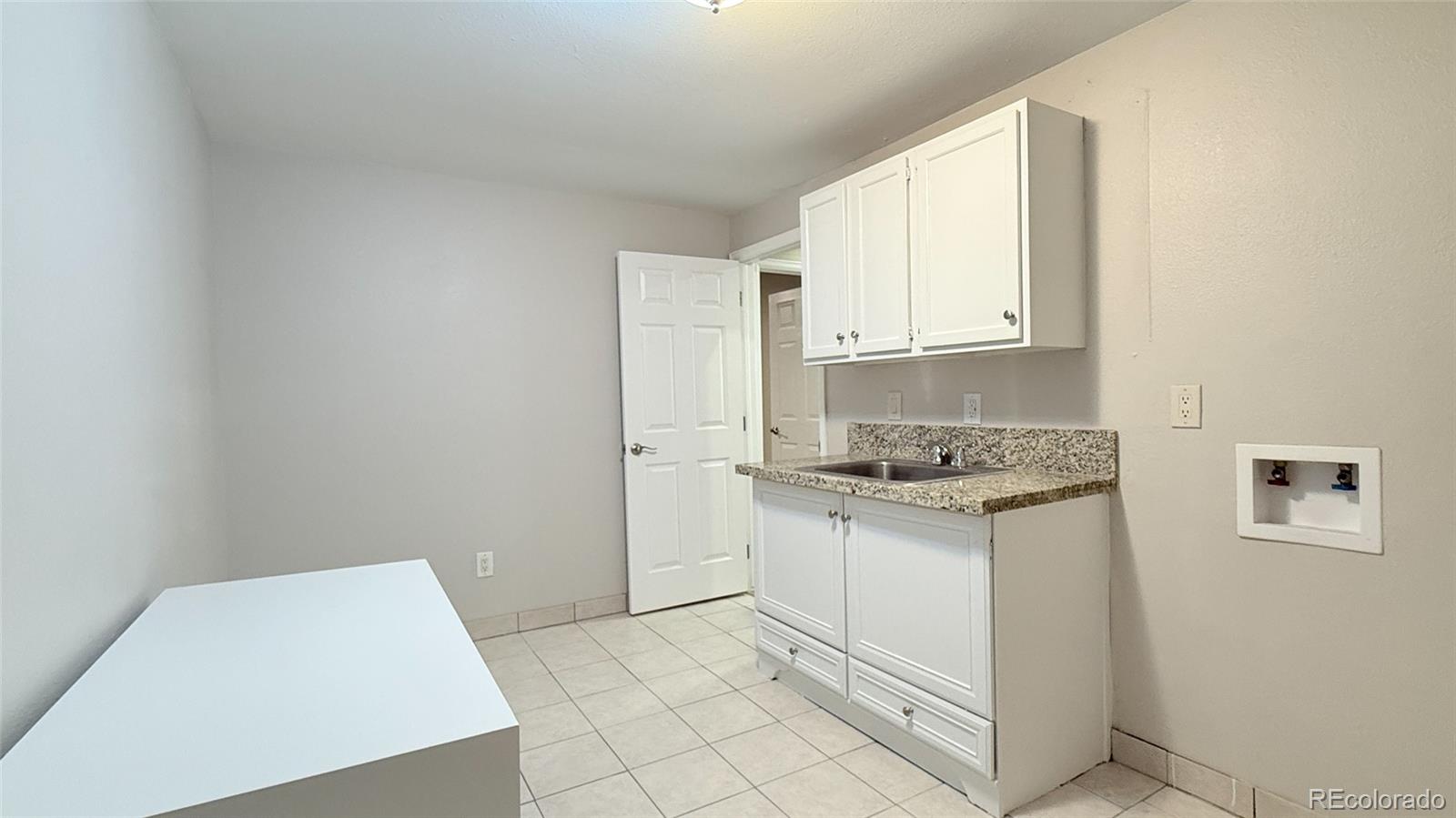 15789 Sandtrap Way Morrison, CO 80465 - Photo 31 of 42 a kitchen with granite countertop white cabinets and white appliances