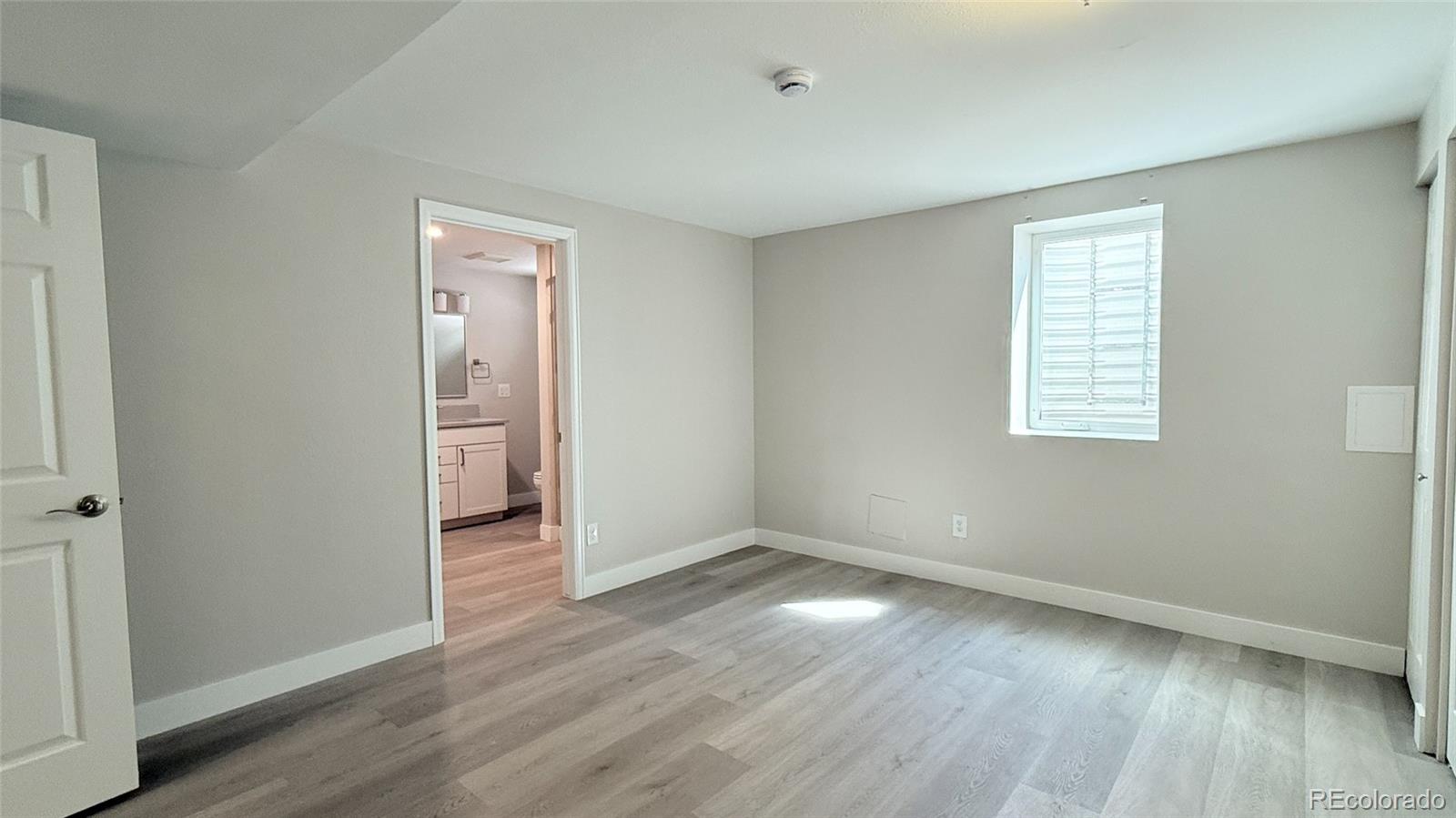 15789 Sandtrap Way Morrison, CO 80465 - Photo 32 of 42 an empty room with wooden floor and windows