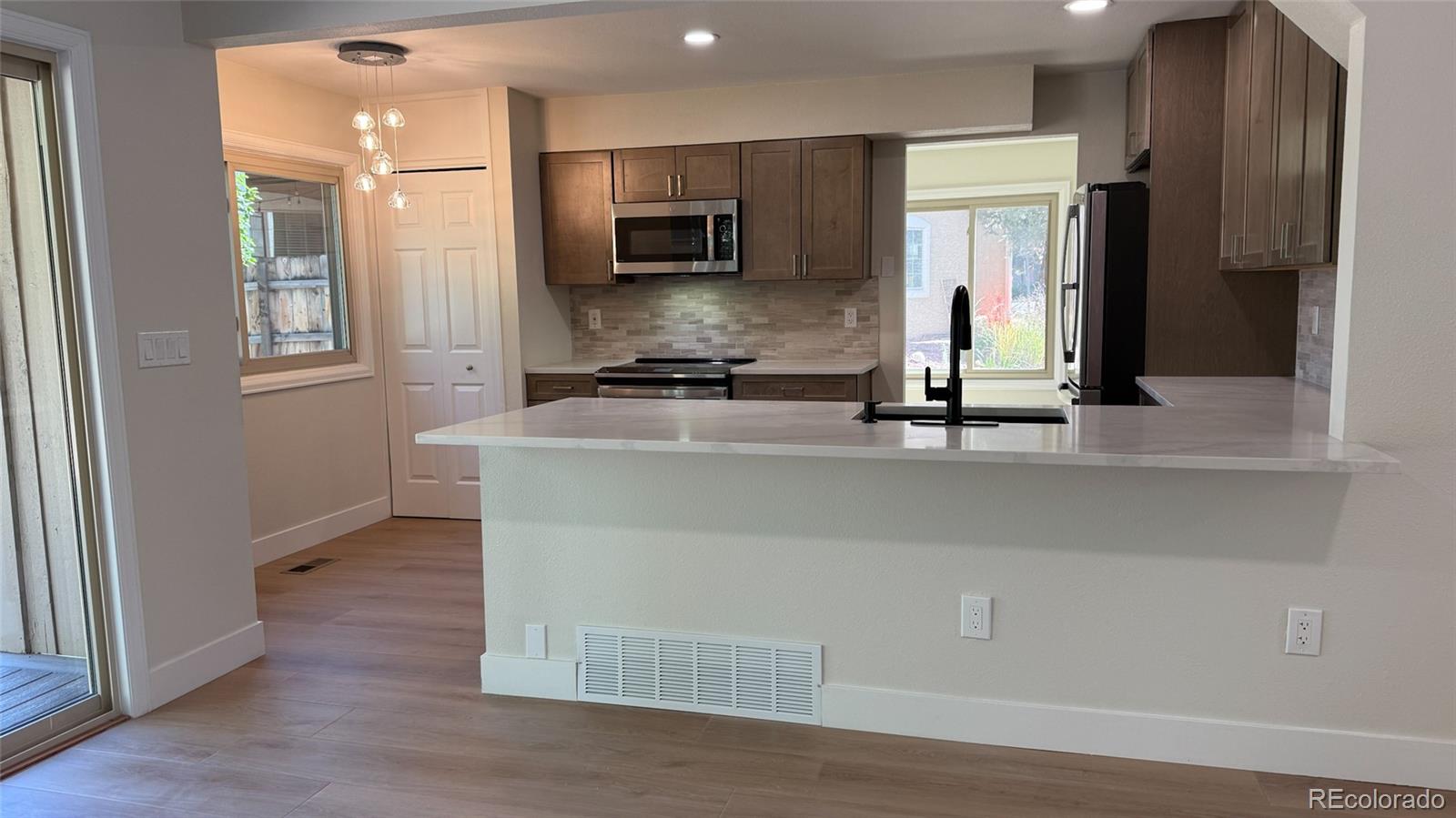15789 Sandtrap Way Morrison, CO 80465 - Photo 36 of 42 a kitchen with kitchen island a counter top space a sink and a refrigerator