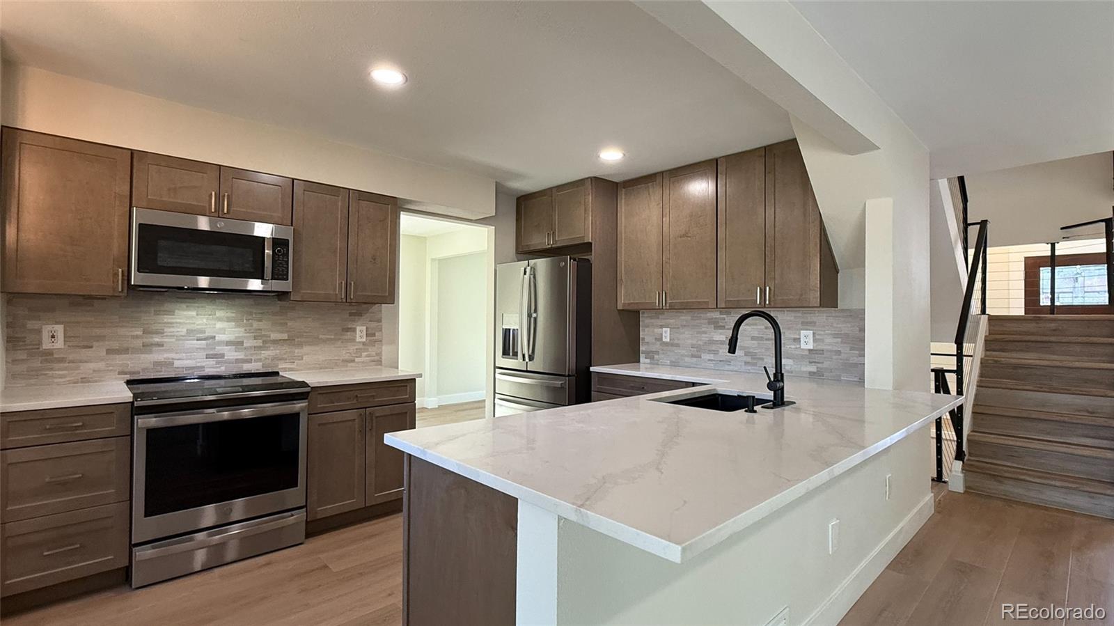 15789 Sandtrap Way Morrison, CO 80465 - Photo 5 of 34 a kitchen with stainless steel appliances granite countertop a sink a stove top oven and refrigerator