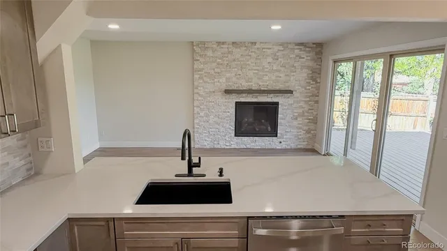 a close view of a sink a faucet and a stove in the kitchen