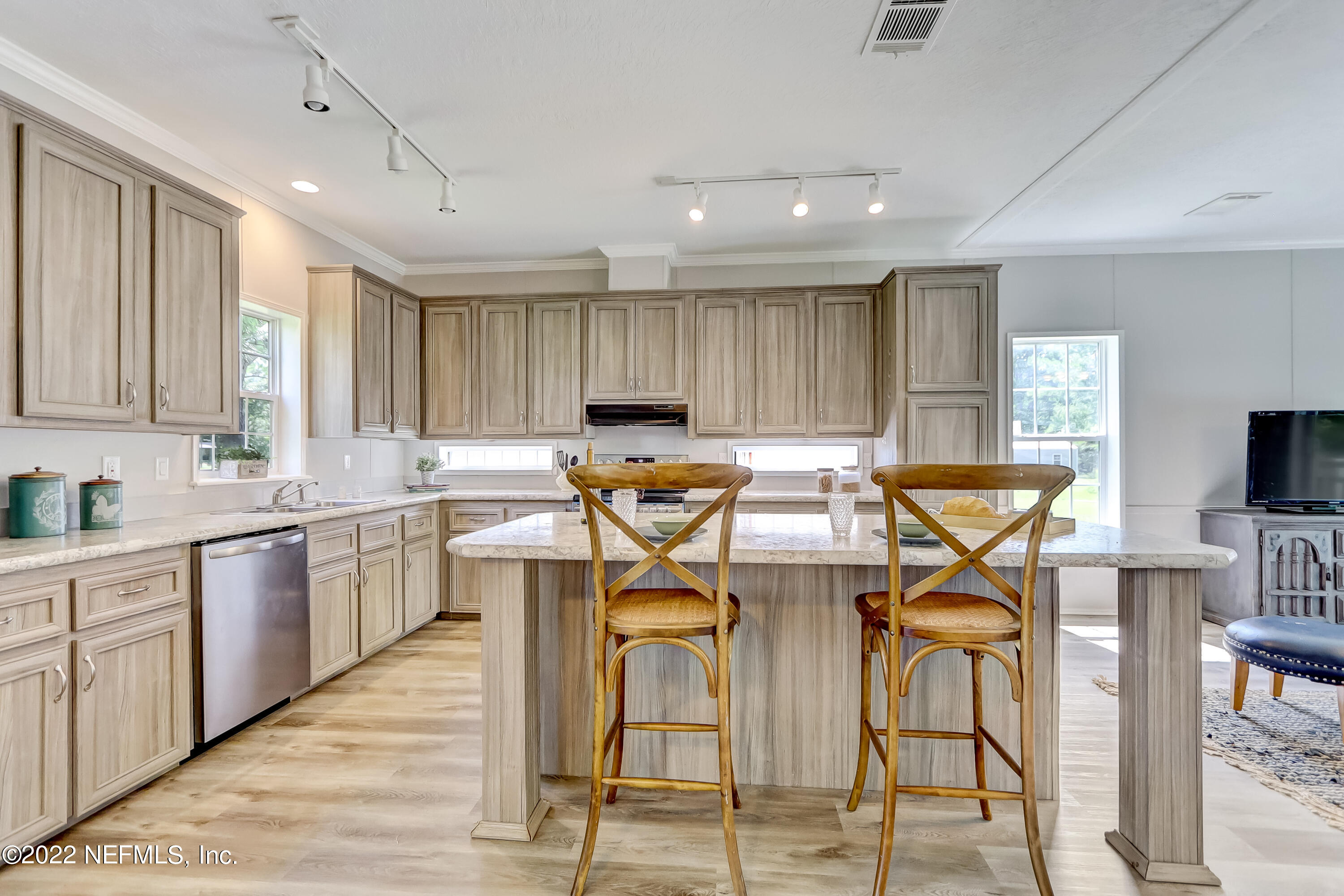 54267 Heller Road Callahan, FL 32011 - Photo 11 of 37 a kitchen with stainless steel appliances granite countertop a stove top oven a sink a dining table and chairs with wooden floor