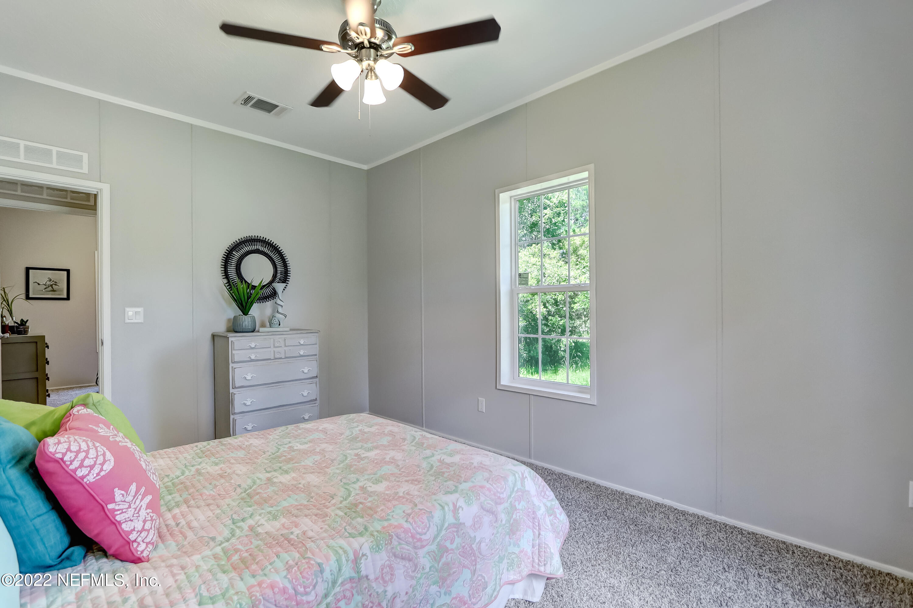 54267 Heller Road Callahan, FL 32011 - Photo 34 of 37 a bedroom with a bed and dresser with mirror