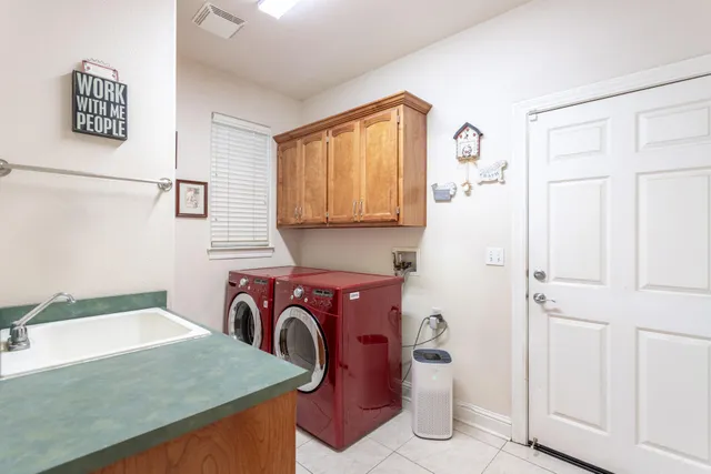 a utility room with cabinets washer and dryer