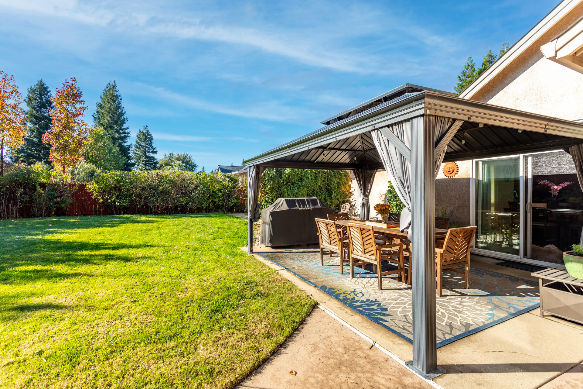 2877 Green Riffle Road Redding, CA 96002 - Photo 26 of 37 a view of a patio with table and chairs potted plants and floor to ceiling window
