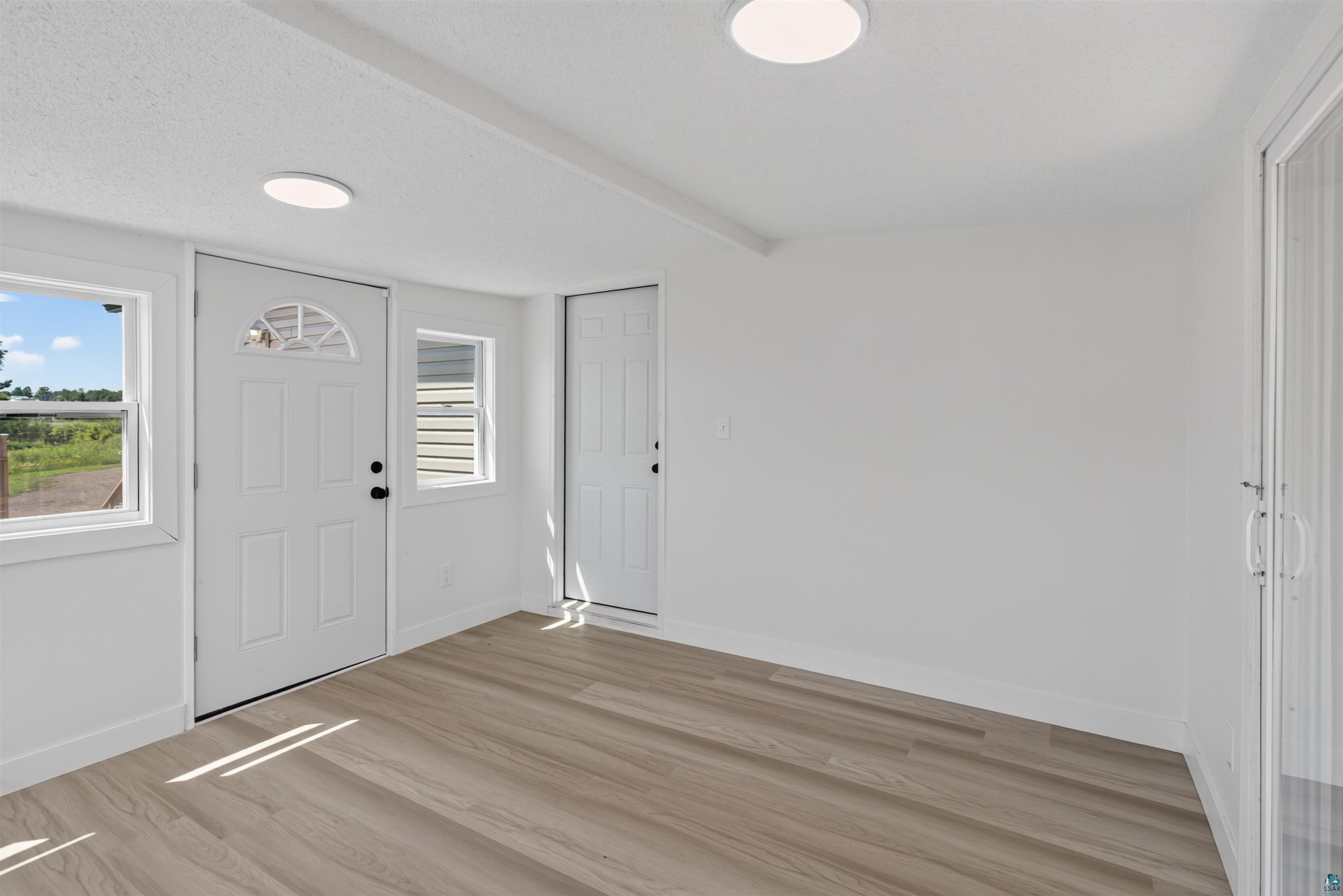 5868 Rice Lake Road Duluth, MN 55803 - Photo 19 of 39 Entryway with light wood-finish flooring, white walls, and two ceiling-mounted light fixtures