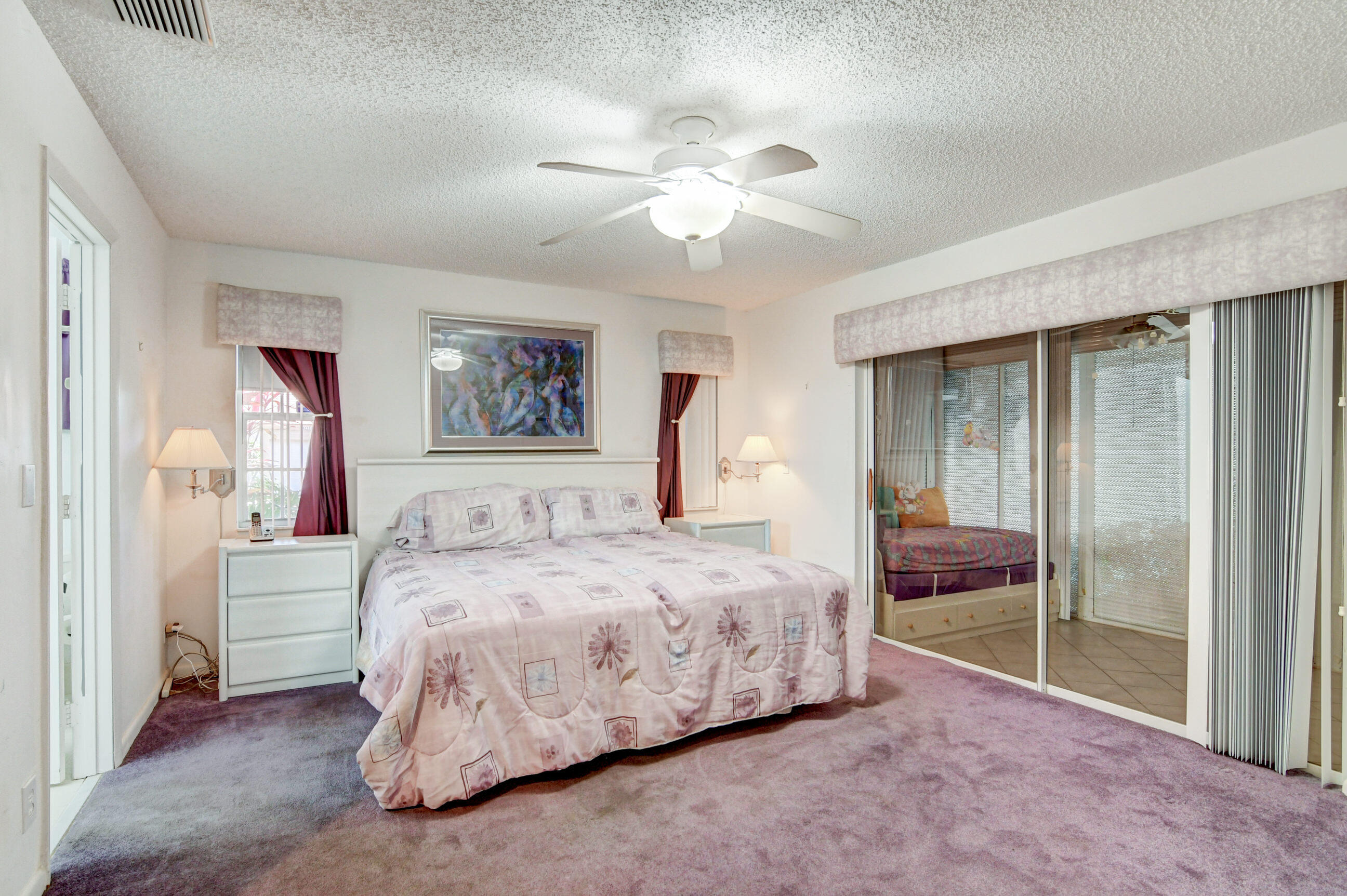 7566 Red Ruby Drive Delray Beach, FL 33446 - Photo 21 of 44 a bedroom with a large bed and a chandelier