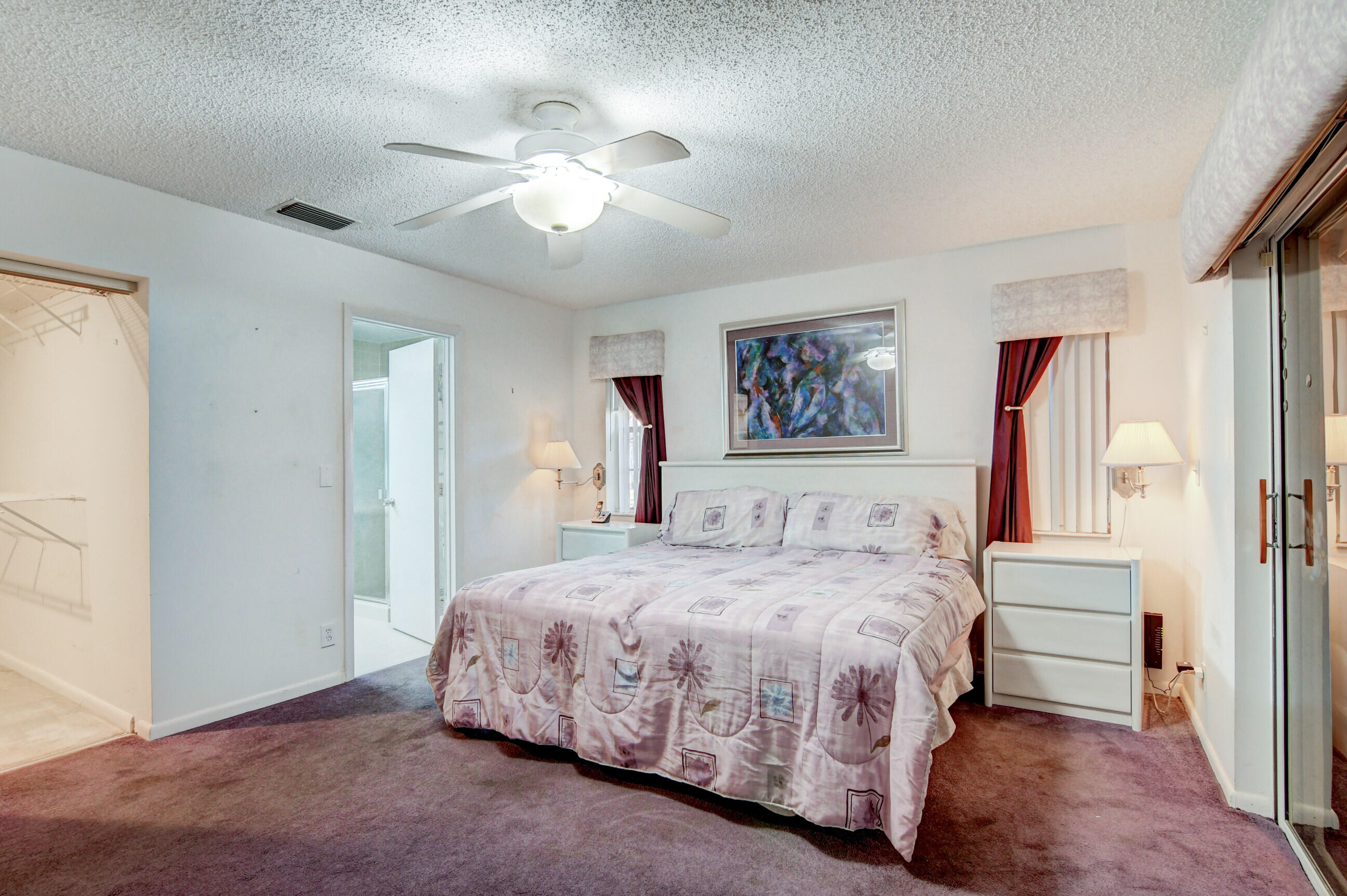 7566 Red Ruby Drive Delray Beach, FL 33446 - Photo 22 of 44 a bedroom with a large bed and a chandelier