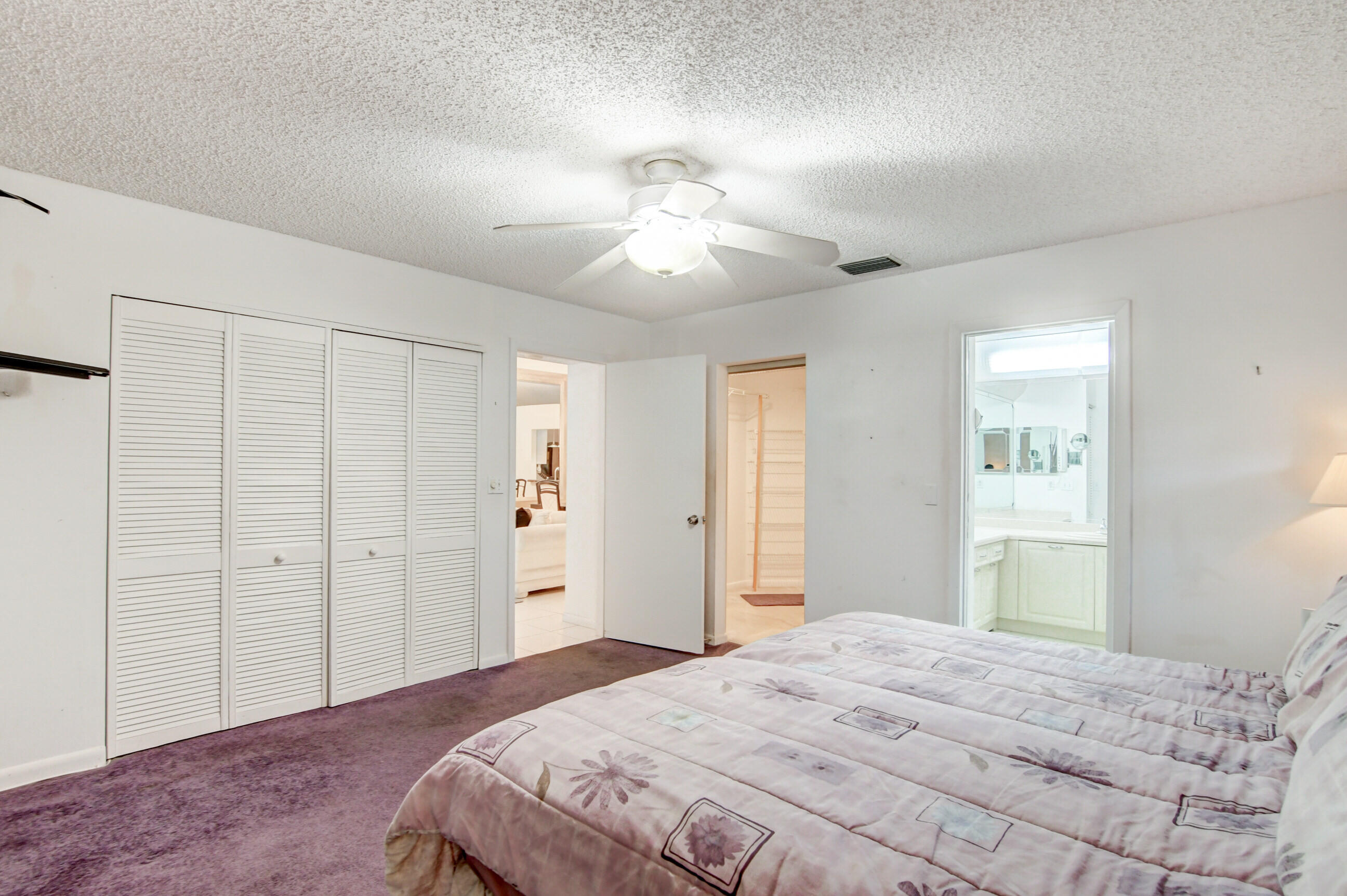 7566 Red Ruby Drive Delray Beach, FL 33446 - Photo 23 of 44 a bedroom with a bed and a chandelier