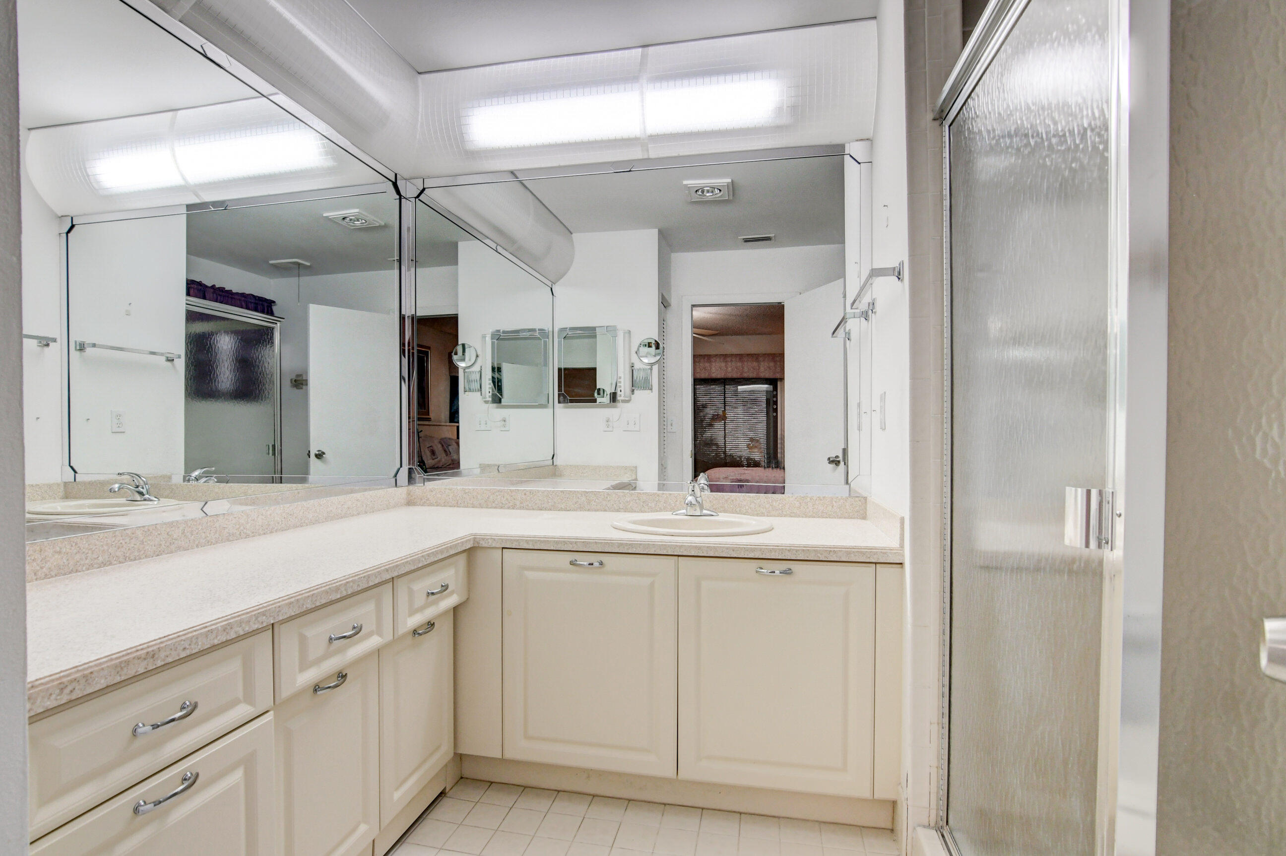 7566 Red Ruby Drive Delray Beach, FL 33446 - Photo 25 of 44 a view of a double vanity sink mirror and cabinets