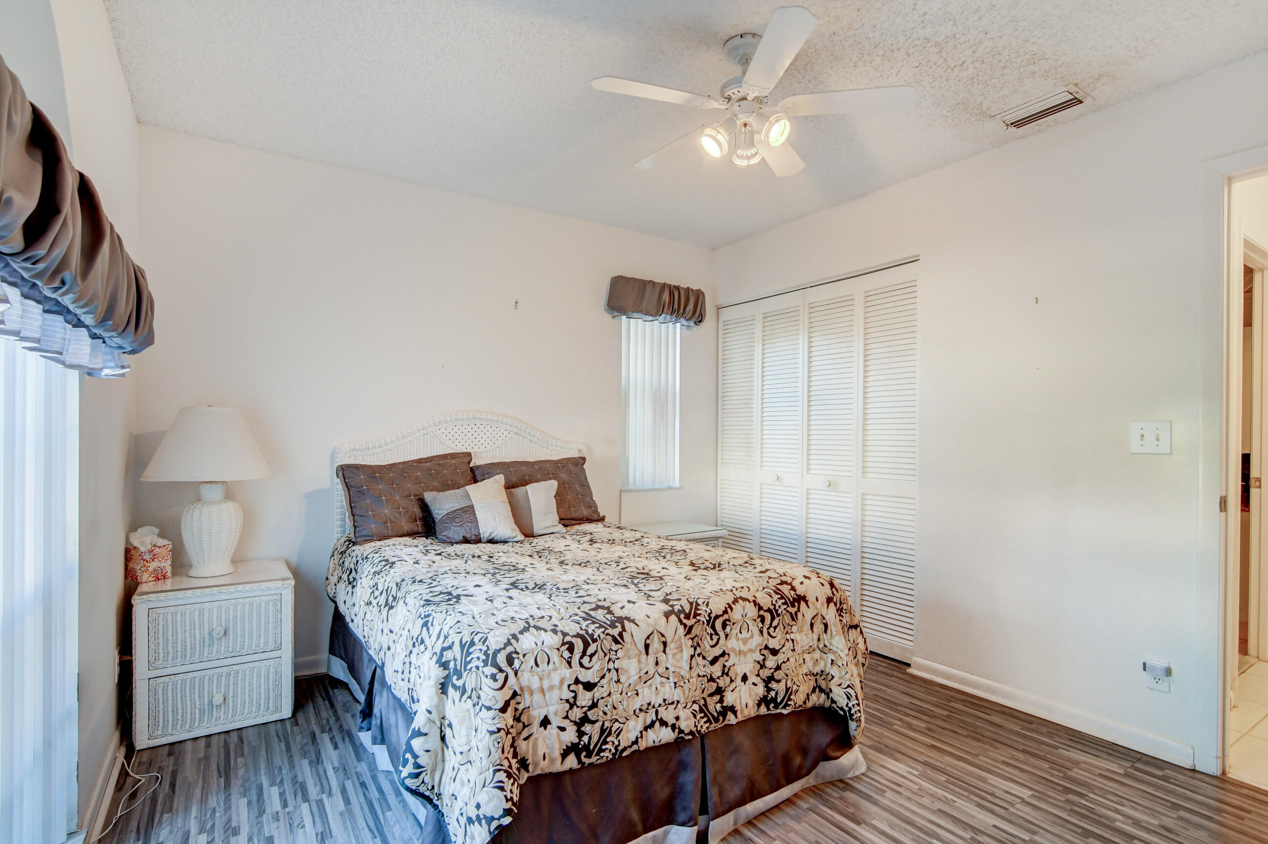 7566 Red Ruby Drive Delray Beach, FL 33446 - Photo 27 of 44 a bedroom with a bed and a chandelier