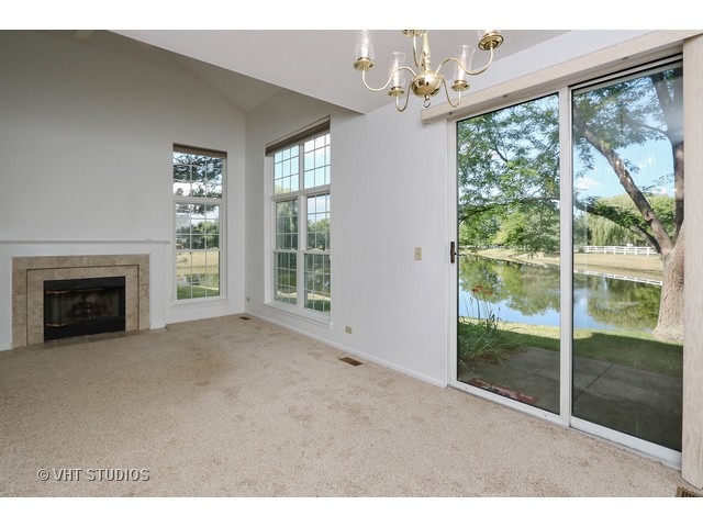 17814 Braewick Road, Unit 17814 Gurnee, IL 60031 - Photo 4 of 10 a view of empty room with floor to ceiling window and fireplace