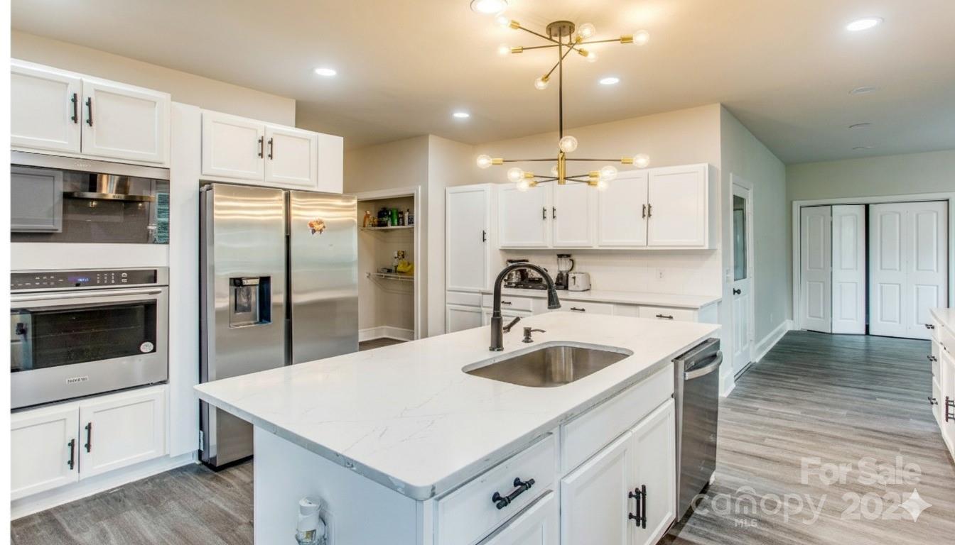 400 Millstone Road Florence, SC 29505 - Photo 13 of 48 a kitchen with a refrigerator a sink and a stove top oven with wooden floor
