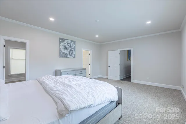 a spacious bedroom with a large bed and a painting