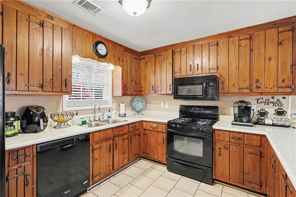 a kitchen with stainless steel appliances granite countertop a sink dishwasher stove and cabinets with wooden floor