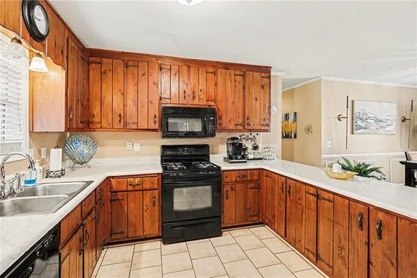 a kitchen with stainless steel appliances a sink cabinets and a window