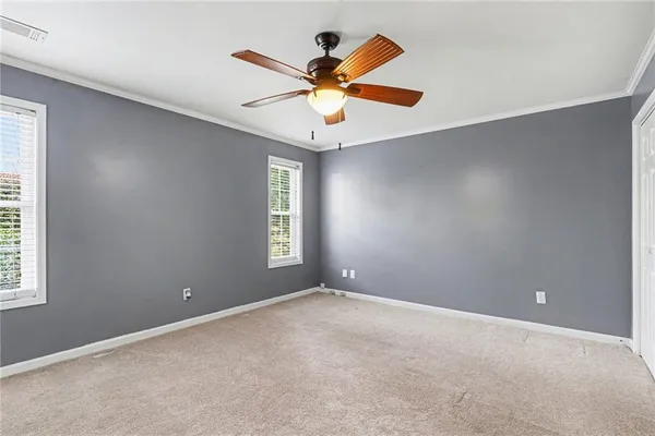 an empty room with windows and fan