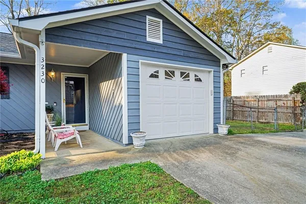 a view of a house with a small yard and wooden fence